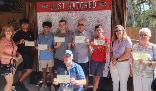 VIPs and mentors with certificates after hatching baby alligators